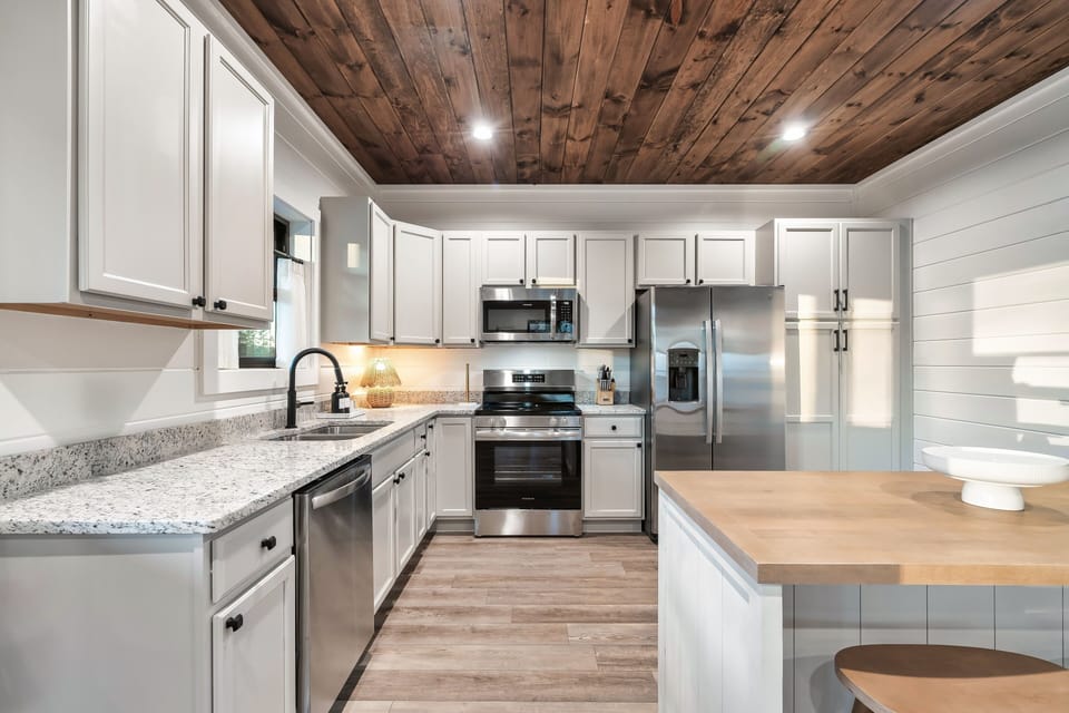 Bright, fully equipped kitchen with a large island, modern appliances, and plenty of space for gathering and meal prep.