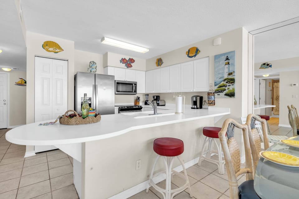 Your bright coastal kitchen features modern appliances and a spacious breakfast bar where you'll enjoy morning coffee surrounded by charming nautical décor.