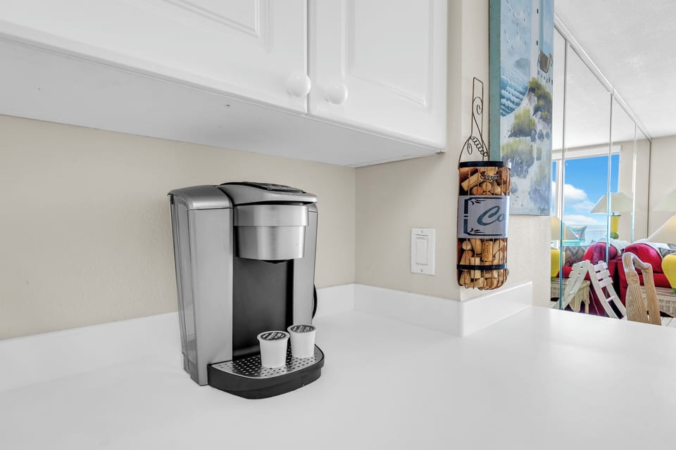 Start your mornings with fresh coffee from your personal single-serve maker, perfectly positioned on pristine countertops in your bright, well-appointed kitchen.