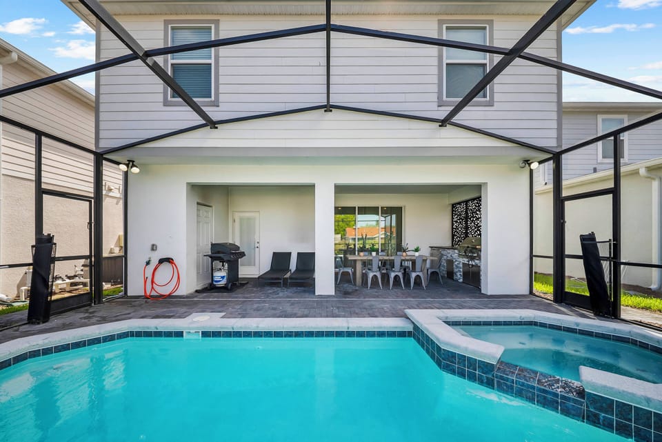 Experience a sunlit outdoor oasis featuring a sparkling pool surrounded by sleek tiles and a spacious screened area. Relax in the inviting seating as you enjoy leisurely afternoons with a vibrant view that brightens your stay.