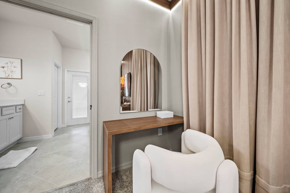 A stylish vanity area invites relaxation, featuring a sleek mirror framed by soft lighting. The warm beige curtains and light wood accents create a soothing atmosphere, perfect for unwinding after a day of adventure.