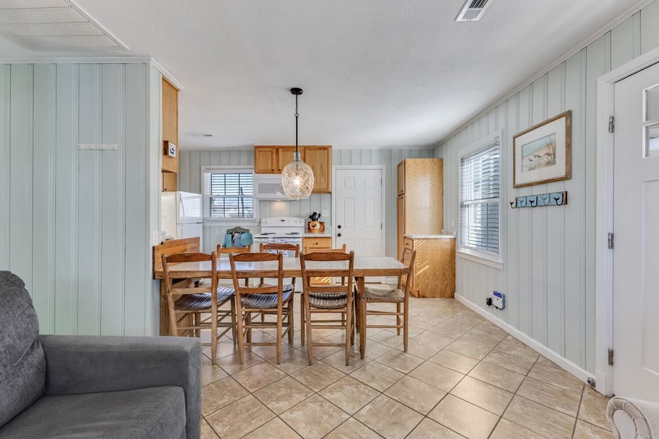 Gather around your spacious dining table for memorable meals in this charming coastal-style space with warm wood tones.