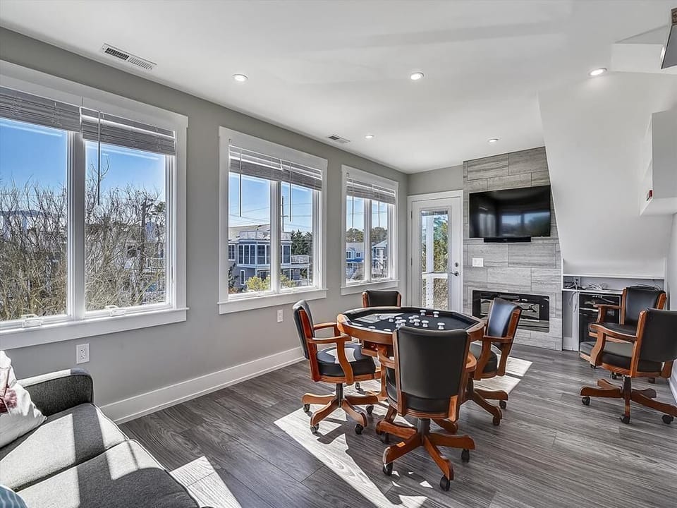 Cozy sunroom, highlighting the comfy seating area and panoramic windows for enjoying the view as well as a fun game with your loved ones.