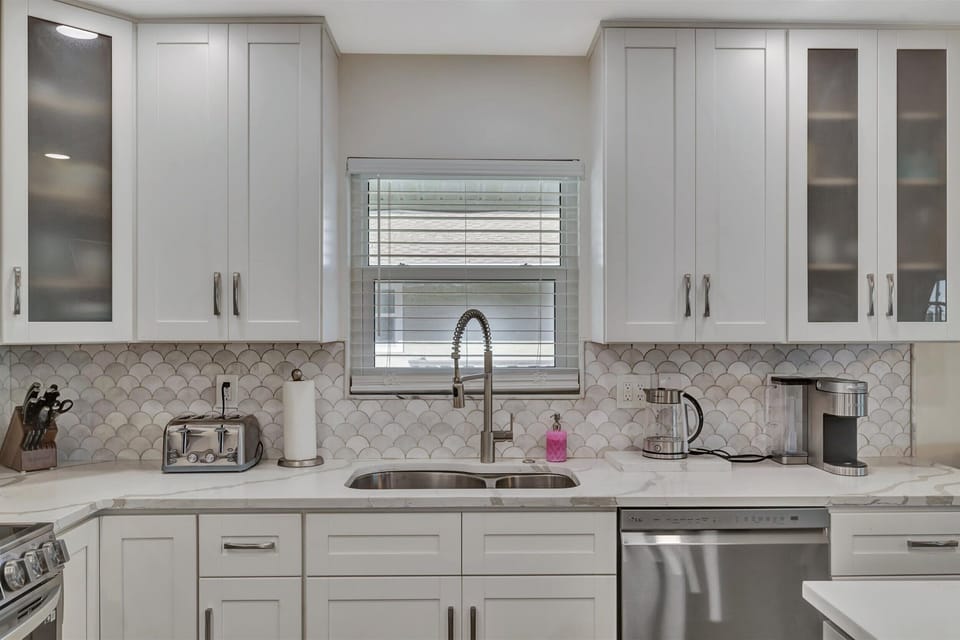 Bright kitchen sink with modern cabinets and stylish backsplash