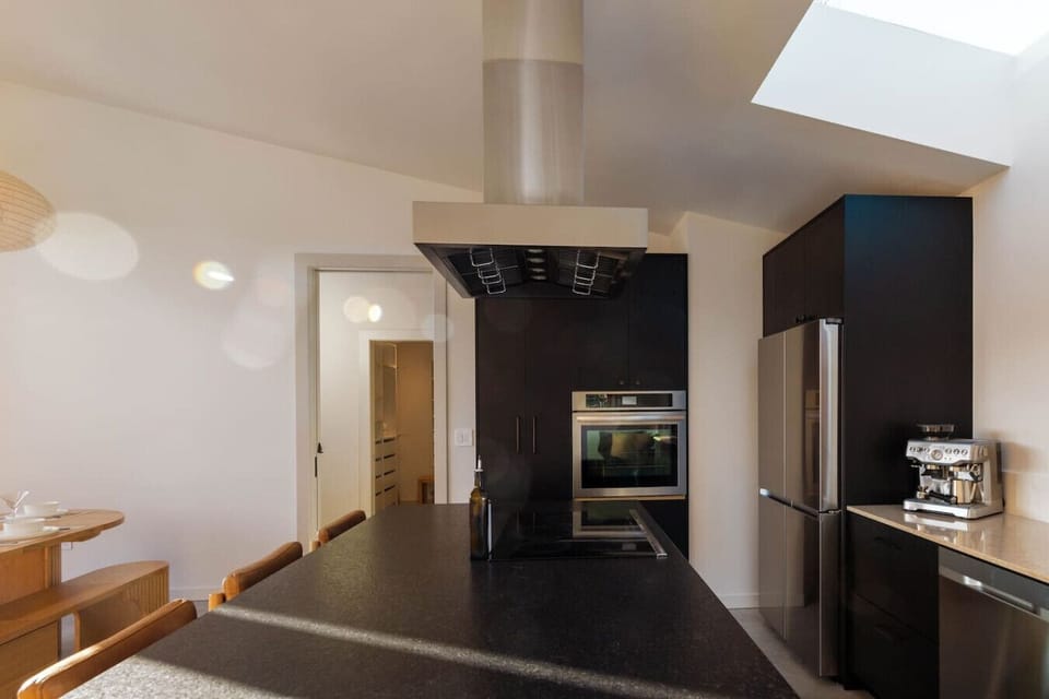 Sleek, chef-ready kitchen featuring dark cabinetry and premium stainless steel appliances.