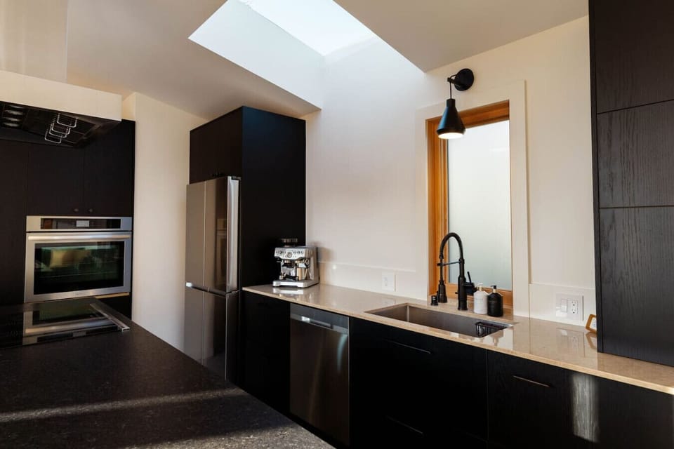 Sleek, fully-equipped kitchen featuring high-end stainless steel appliances.