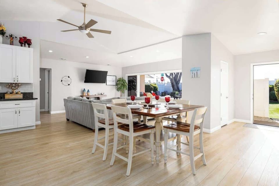 This stylish dining nook comfortably seats four guests with its modern high chairs and warm wooden table. The bright, airy atmosphere enhanced by views of the outdoors and easy access to both the kitchen and living room makes every meal special.