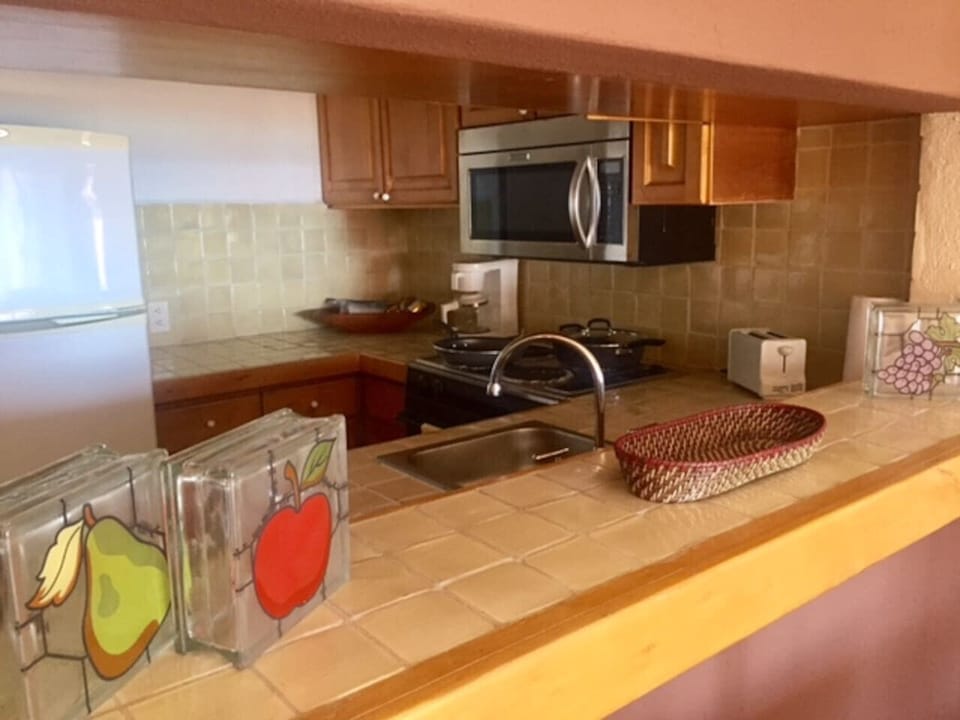 Generous tiled countertop, full appliances, and a practical layout, great for preparing meals and entertaining