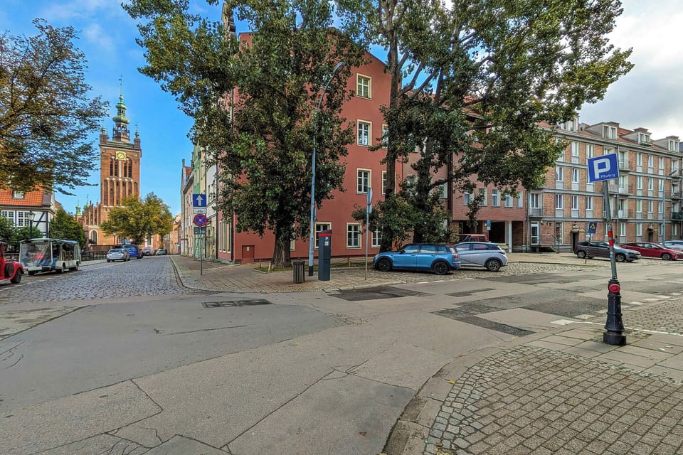 A street view showing surrounding buildings and a nearby intersection. The image reflects a lively yet charming urban neighborhood. The area appears well-connected and suitable for exploring the city on foot.
