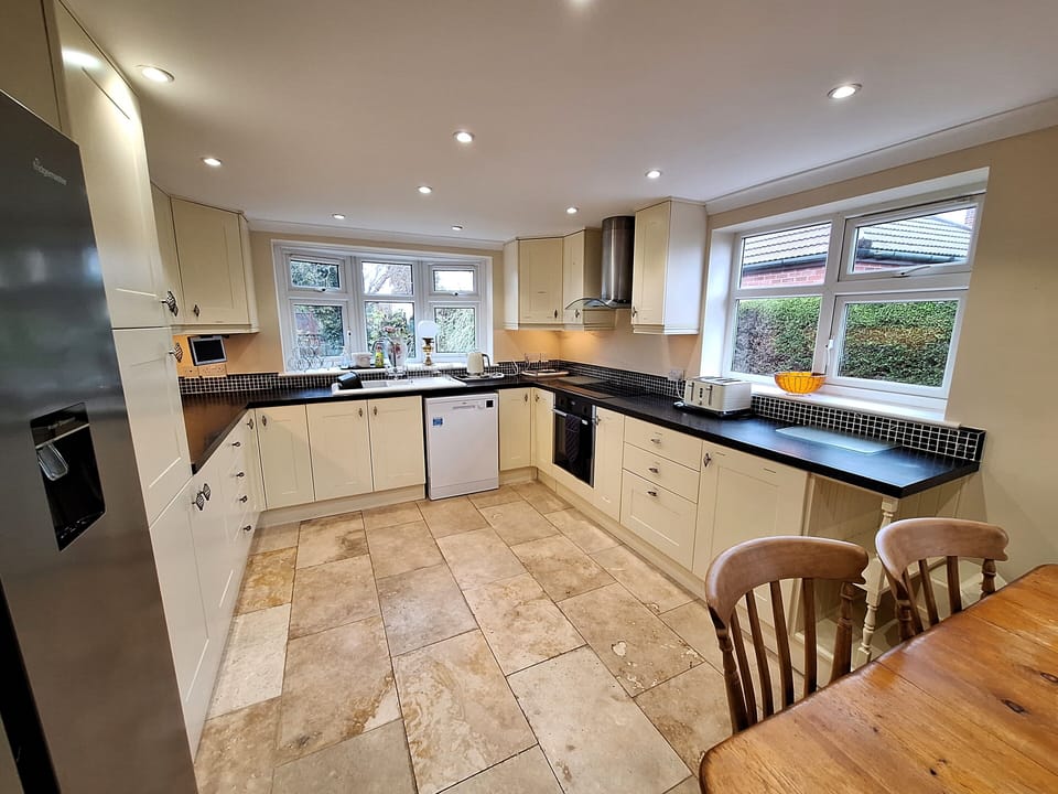 Wide view from dining area into kitchen including appliances.