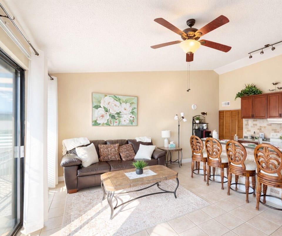 Bright open-concept living area with cozy sofa seating, breakfast bar dining, and natural light—perfect for relaxing after a day on the lake.
