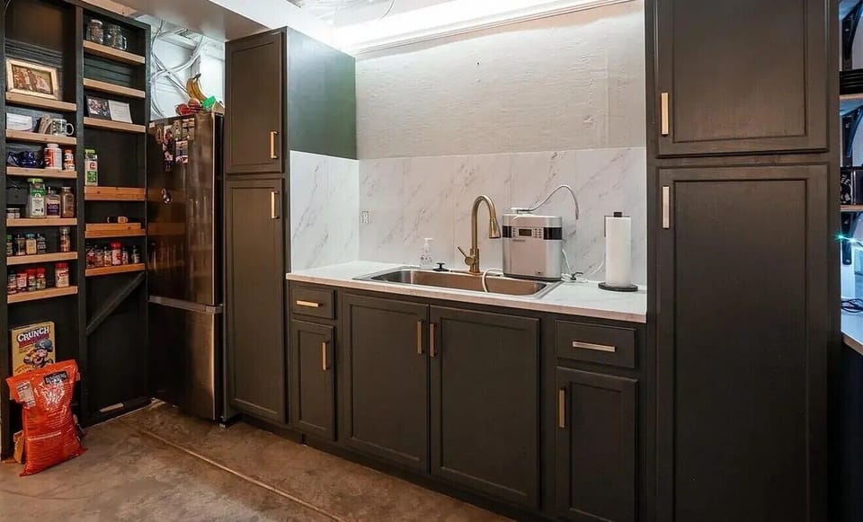 Your fully equipped kitchen features elegant dark cabinetry, marble countertops, and a well-stocked pantry for all your culinary adventures.