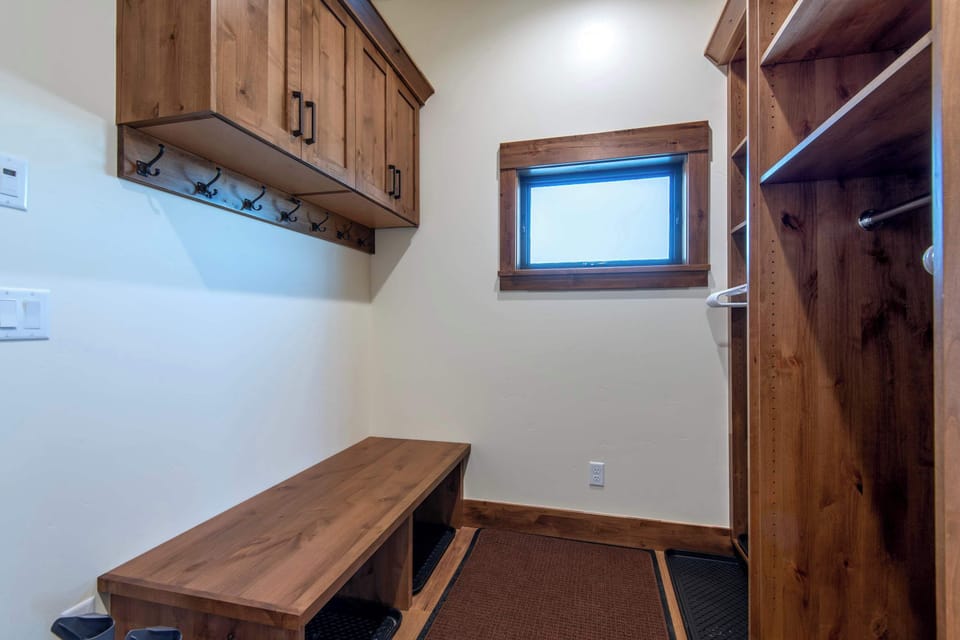 Primary suite closet with built-ins and storage bench.