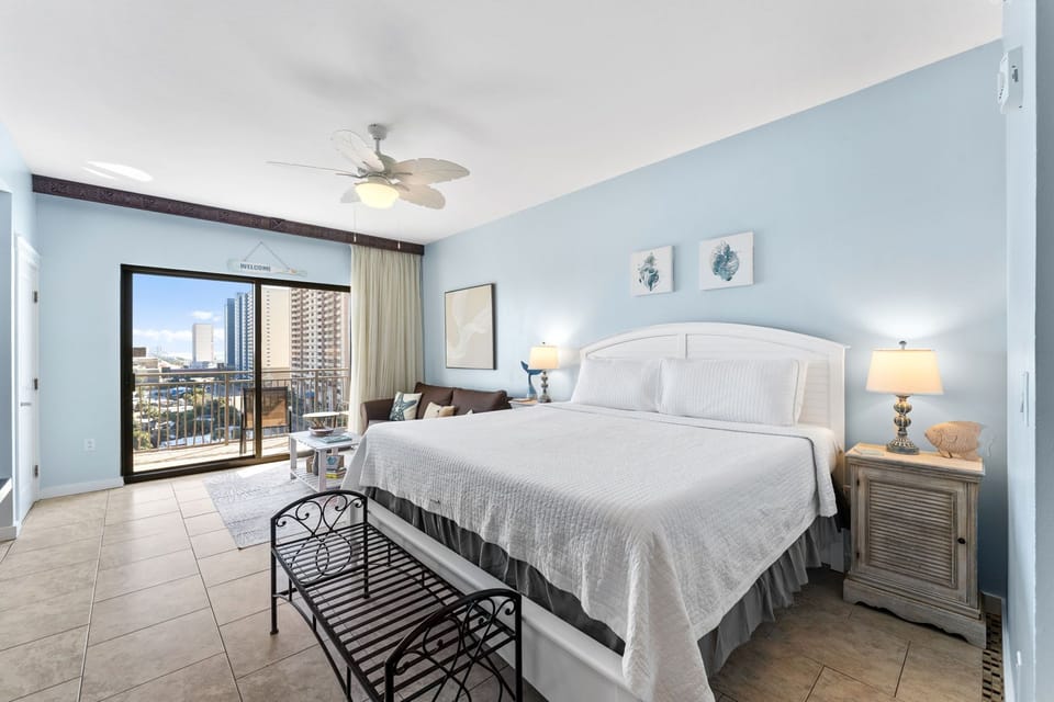 Drift off in this serene coastal bedroom where soft blue walls and crisp linens create your peaceful retreat, with city views greeting you each morning.