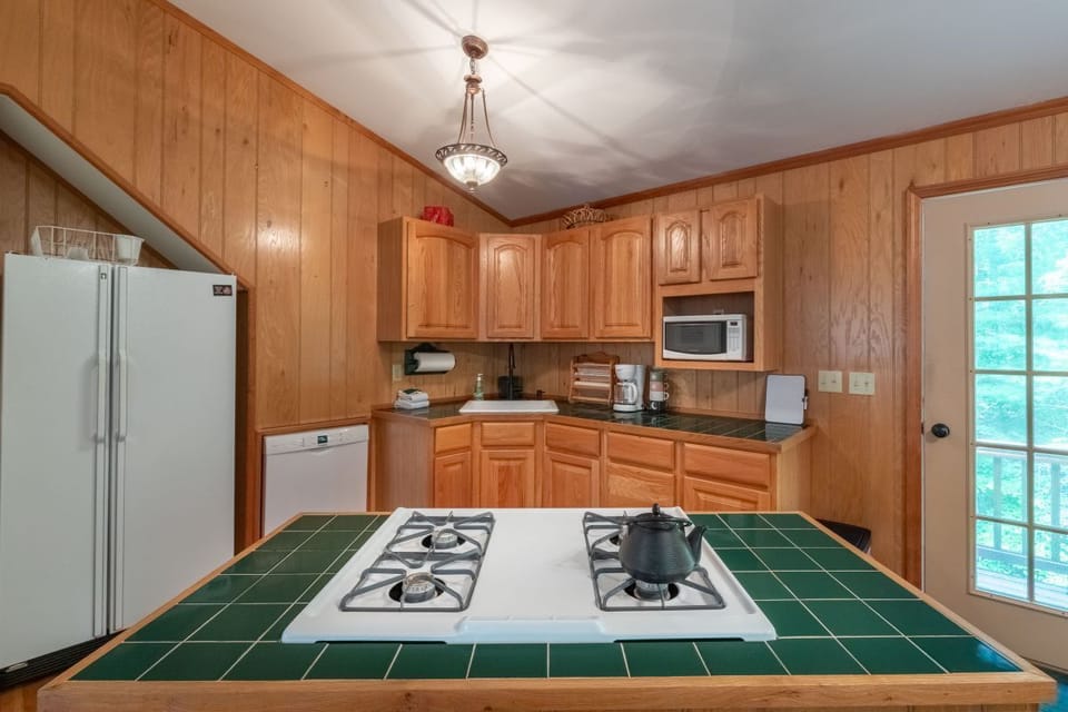 Kitchen: Whip up culinary delights in this charming space with wooden cabinetry and modern appliances!