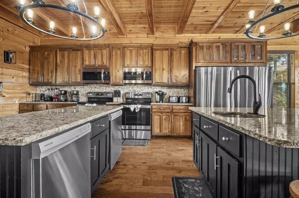 A chef-style kitchen featuring granite countertops, stainless steel appliances, custom wood cabinetry, and a spacious island. Built for both everyday meals and group entertaining in a refined mountain setting.