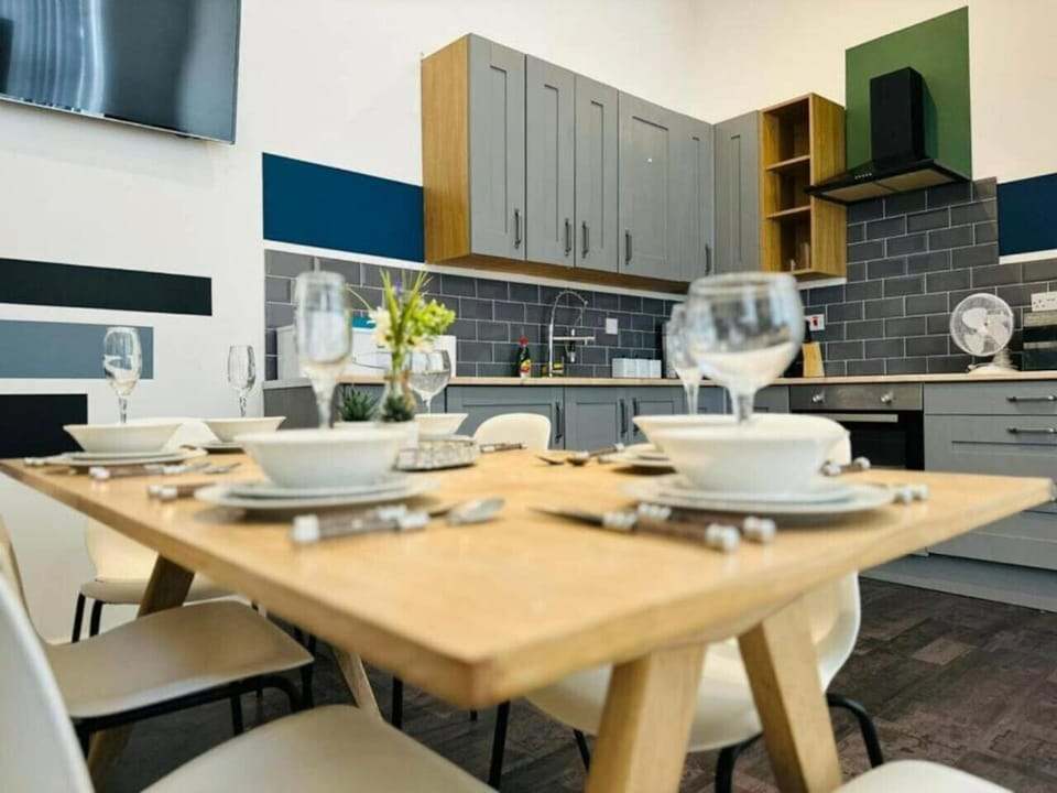 Gather around the dining table set with plates and glassware in the open-plan space.