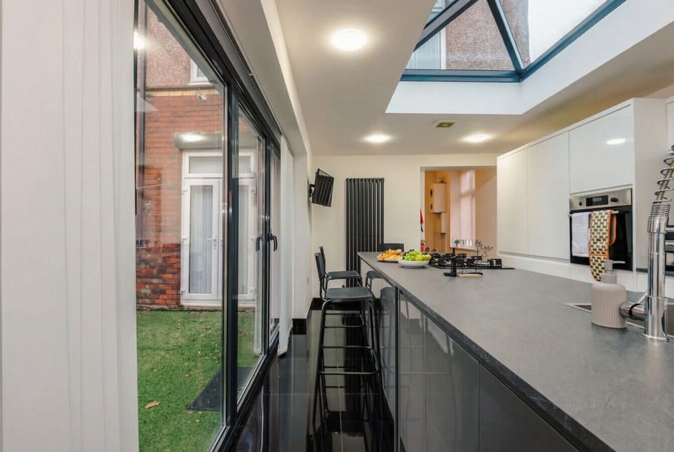 Bifold doors open the kitchen straight onto the private garden and hot tub terrace.