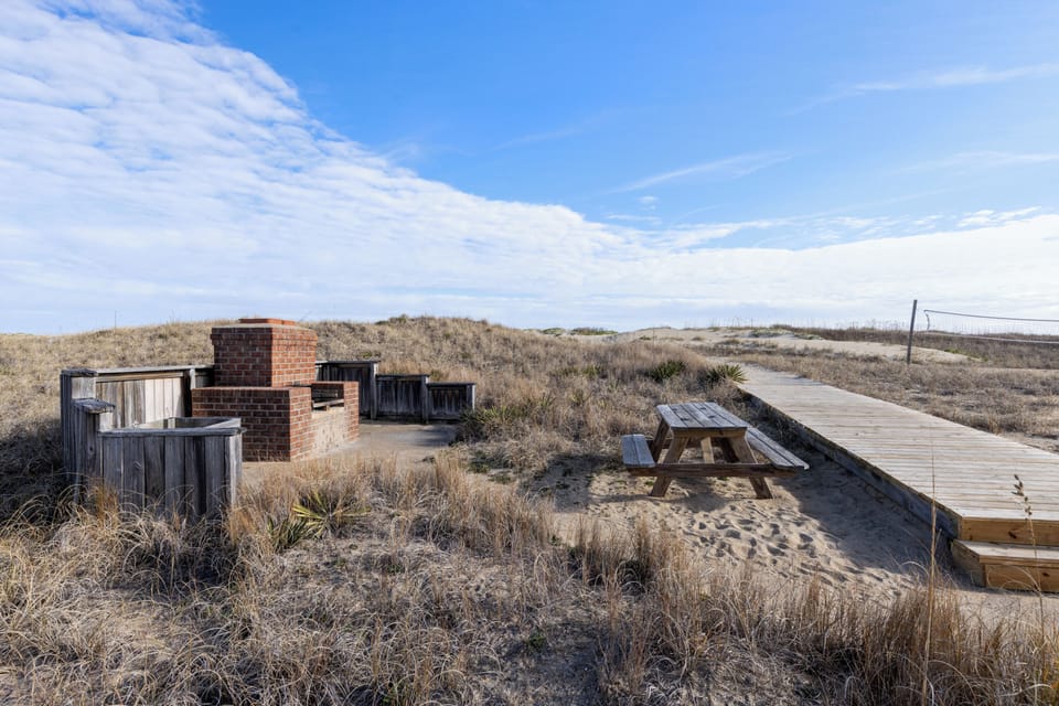 Boardwalk access to the beach with outdoor fireplace grill