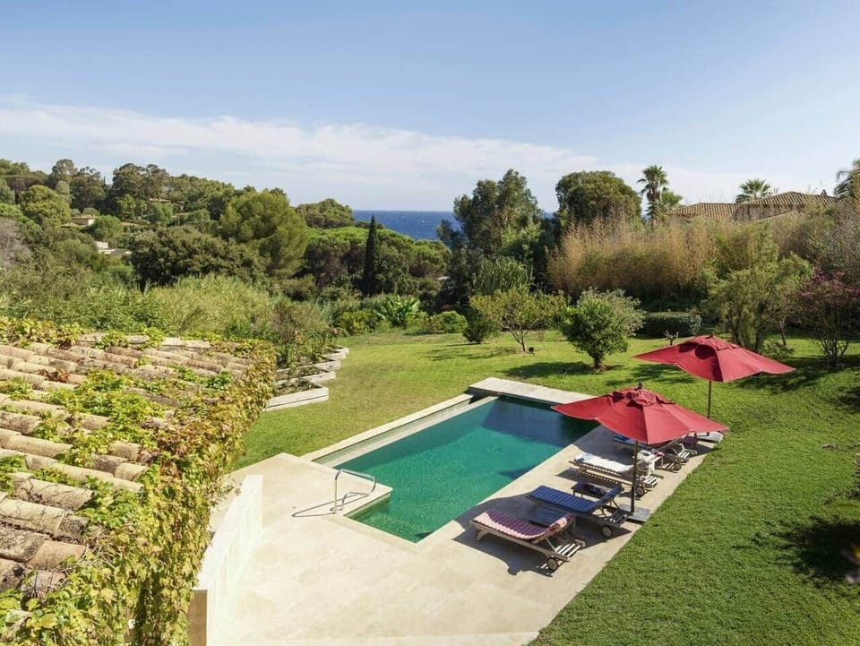 Sur le balcon d'où l'on accède par les chambres, vue sur la piscine, la mer et le jardin