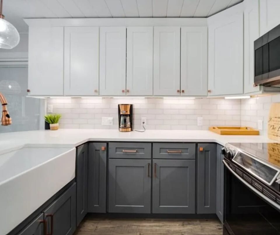 Stylish modern kitchen with farmhouse sink, quartz countertops, and stainless steel appliances
