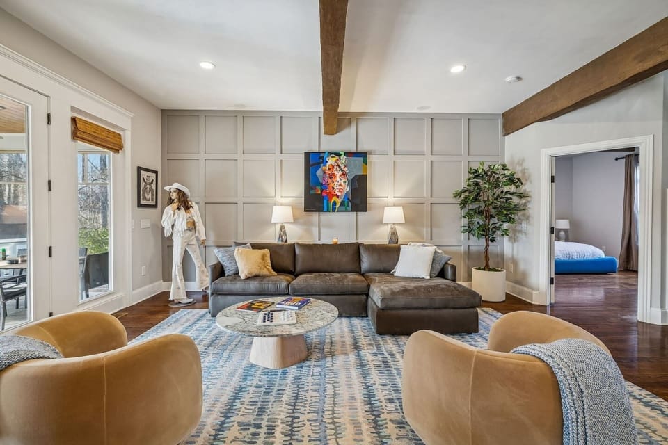 Upscale furnished Living Room with a leather chaise sofa with views of the lake, kitchen and 65" TV over the fire place