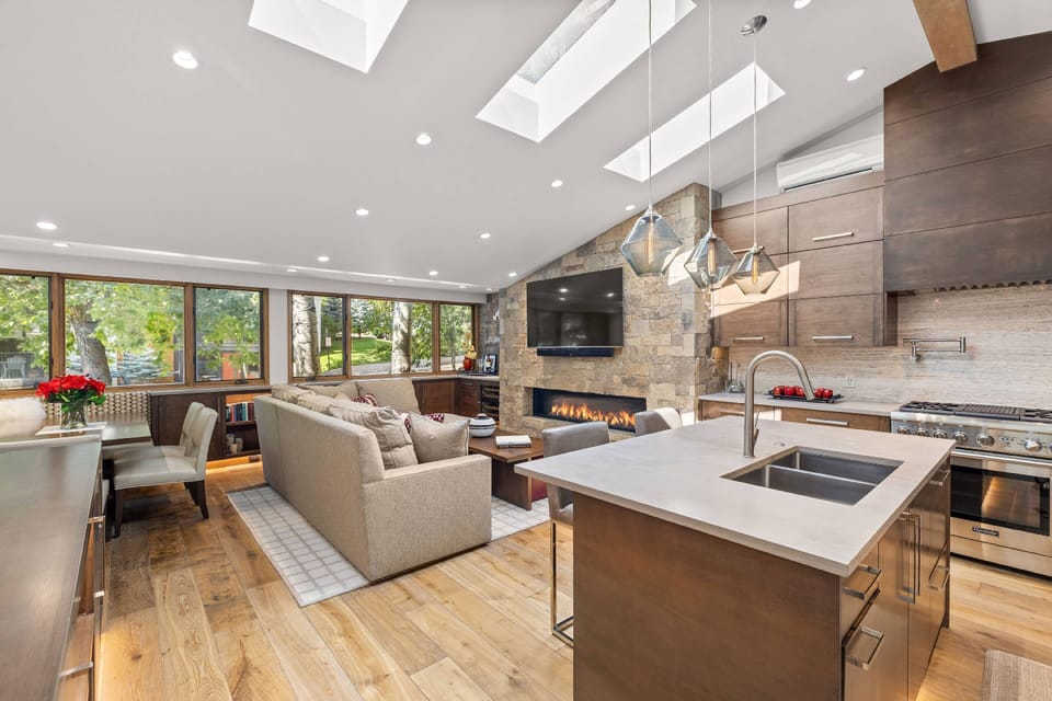 Soaring skylit ceilings unite the kitchen, dining, and living areas into one seamless, light-filled entertaining space.