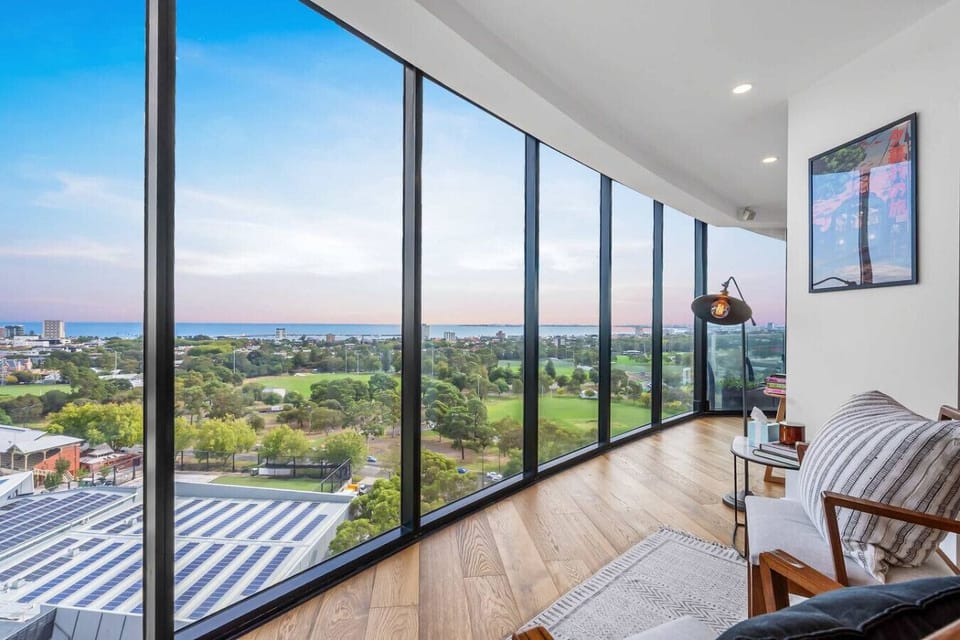 Floor-to-ceiling windows line the living space, opening to wide views of the park and surrounding city. Natural light fills the room, creating a calm, airy setting to relax, read, or enjoy the outlook throughout the day.