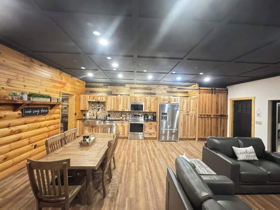 Spacious living area with smart TV, dining room table, and fully stocked kitchen.