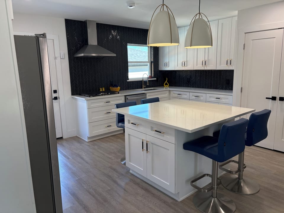 Open kitchen with large center island with 4 dining stools.