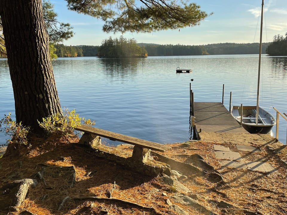 Peaceful lakeside setting with private dock and boat access surrounded by pristine wilderness.