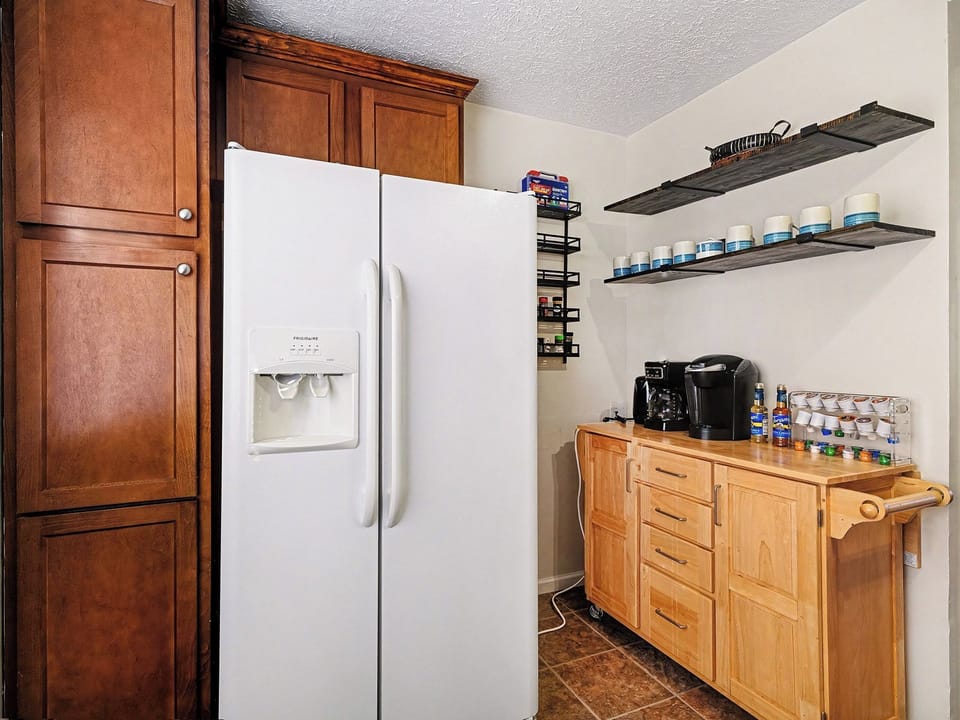 Fully stocked kitchen featuring a refrigerator and a convenient coffee station.
