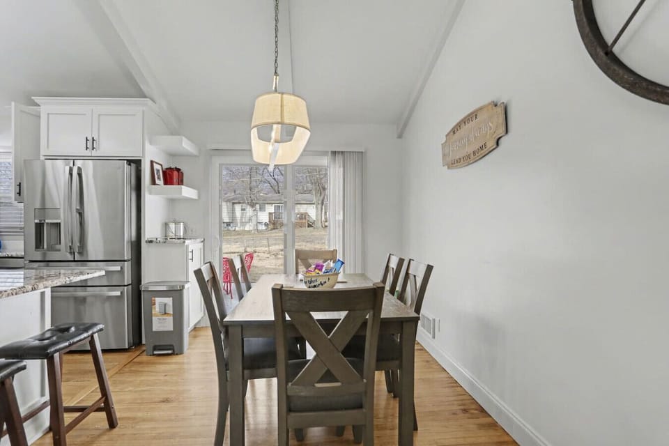 Dining space with contemporary lighting fixture and seating for shared meals before heading to Arrowhead Stadium or The Plaza.  Up to 9 people can enjoy the mail at the dining room table and bar seating.