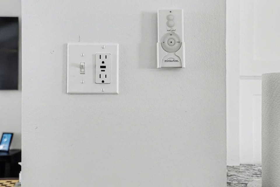 Modern thermostat and light controls for convenient climate management year-round.  (2) USB-A and USB-C charging ports integrated in outlet in the kitchen area. Portable fan controls for (5) ceiling fans throughout the house.