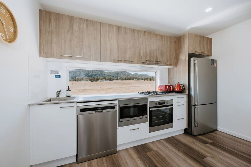 Prepare meals in the well-equipped kitchen with modern appliances and generous bench space, all while taking in calming paddock views.