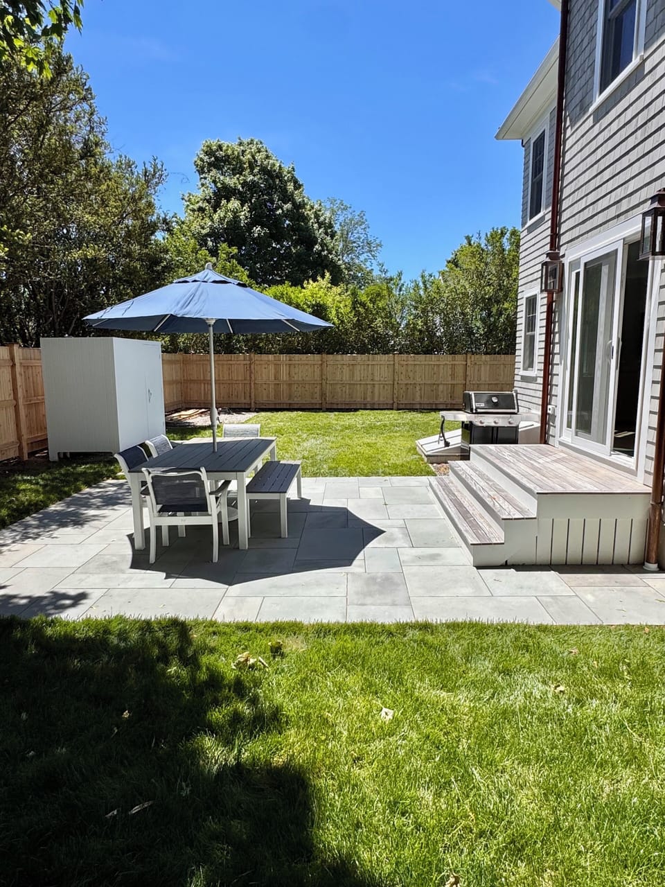 Private back patio with table to seat 6 people, outside shower and grill.