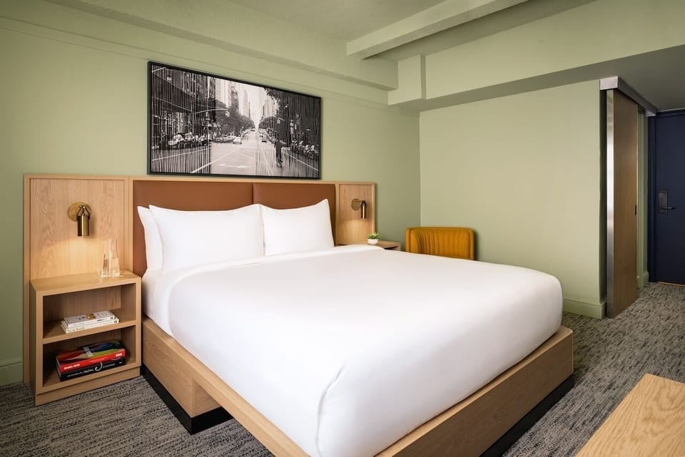 Unwind in crisp linens beneath warm, modern bedside lighting.
