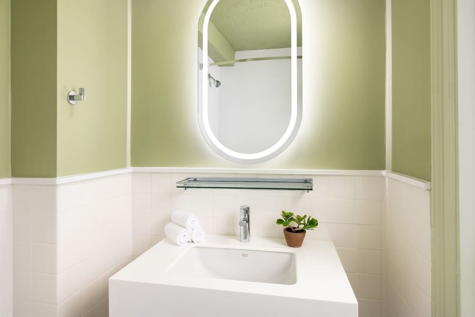 Refresh at a sleek vanity with glowing mirror lighting.