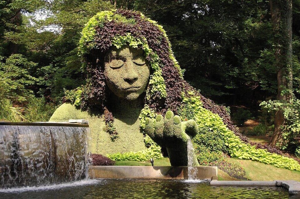 Wander past whimsical greenery art in a serene garden setting.