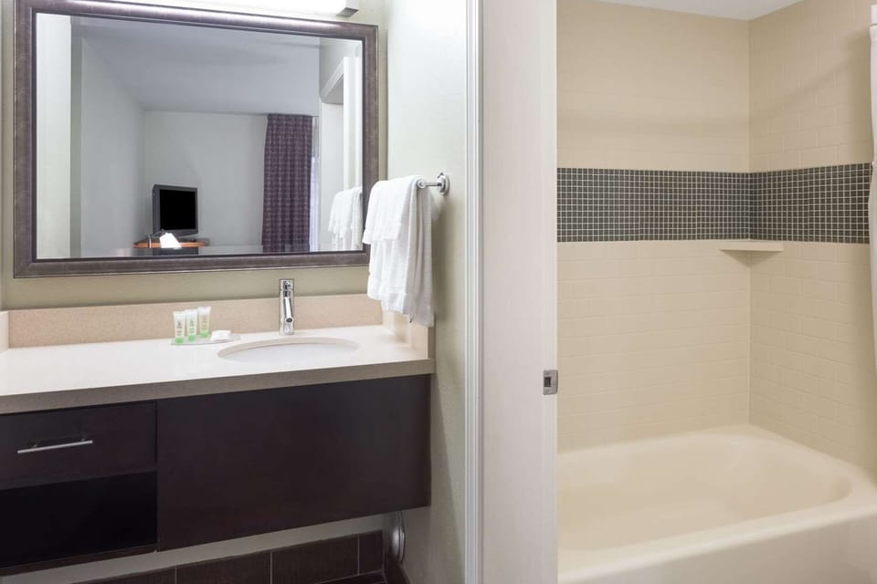 Refresh with a bright vanity, plush towels, and tub-shower.