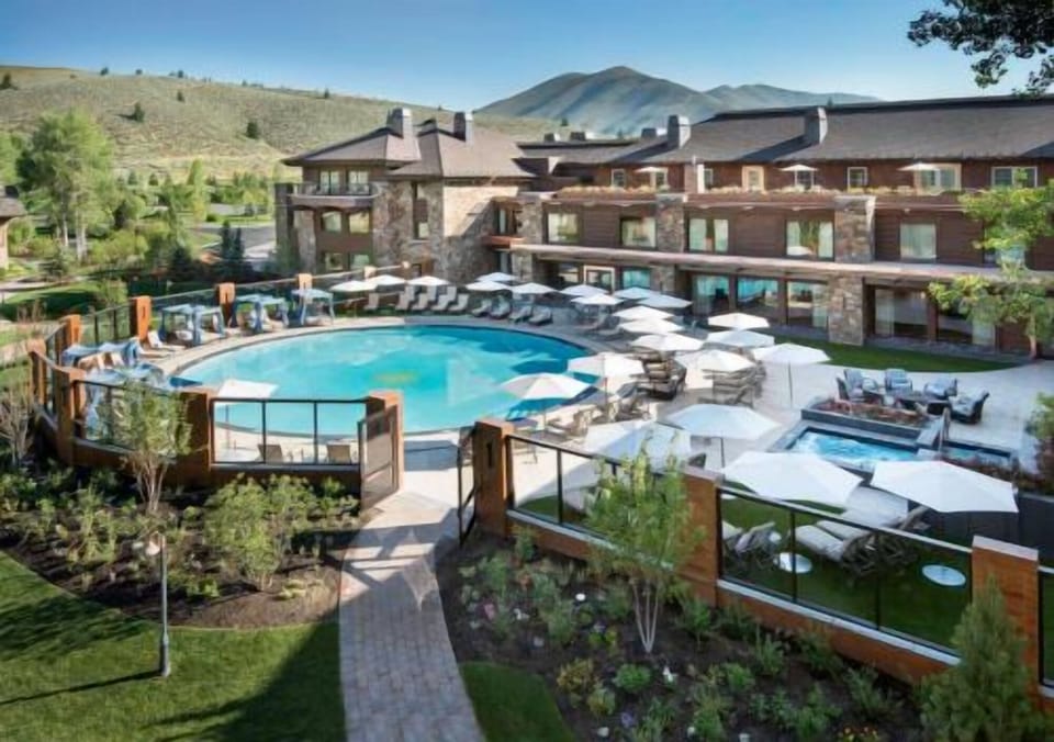 Dive into a sunlit resort pool framed by mountain views.