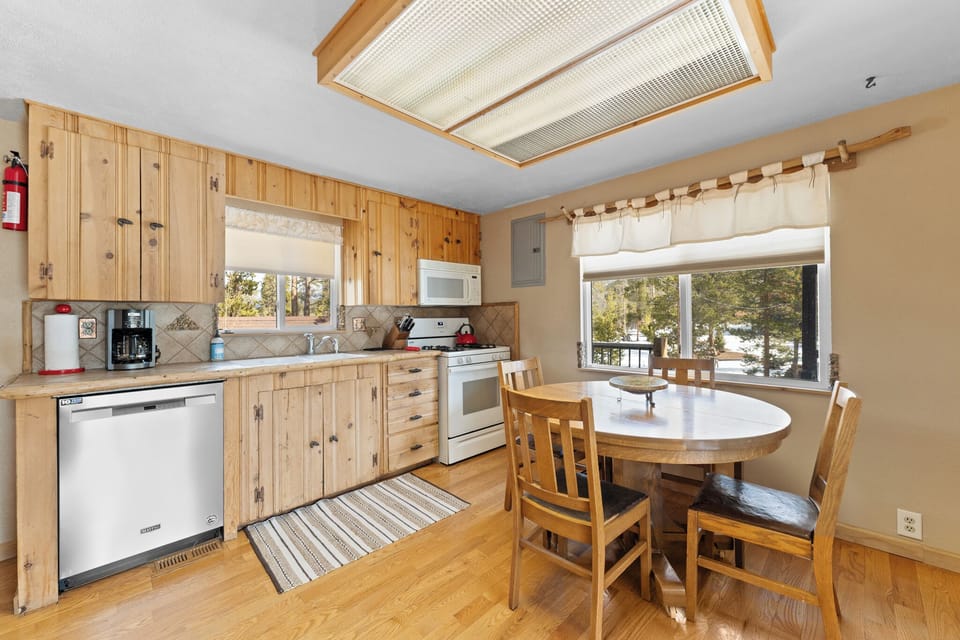 Your charming kitchen combines rustic wood cabinets with modern appliances, creating a cozy space perfect for preparing meals and enjoying mountain views.