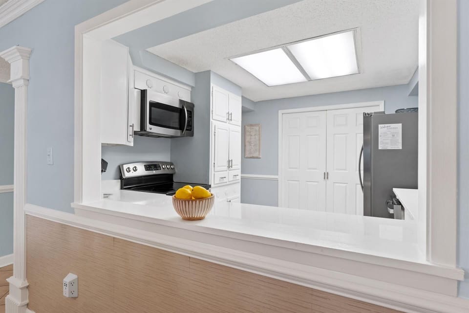 Your bright kitchen opens up with sleek white cabinets, modern appliances, and a spacious island perfect for cooking memorable meals.