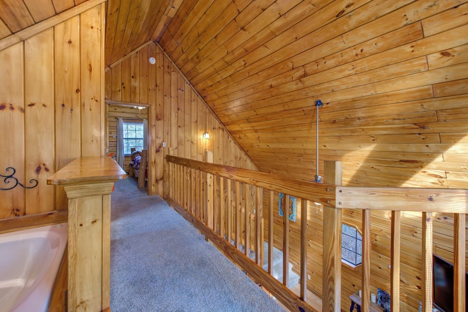 Step into your cozy loft hallway, where rich wood surrounds you in warmth and rustic charm throughout.