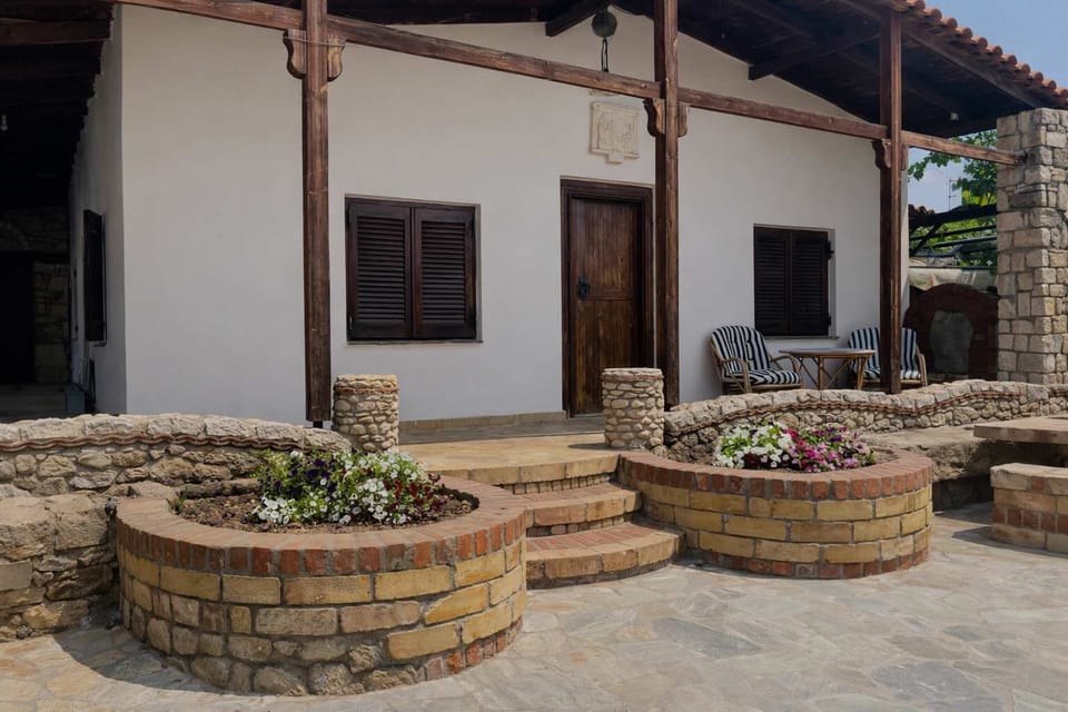 Traditional stone veranda with arches, offering shaded seating and charming outdoor space.