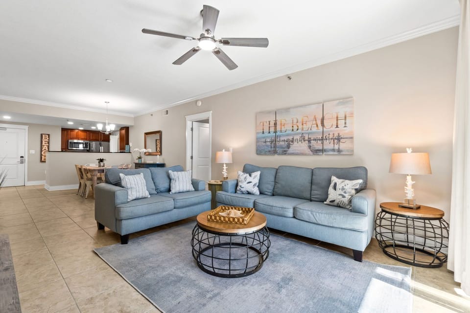 Open-concept living space with cozy sleeper sofa, large Smart TV, and beautiful natural light from the balcony access.