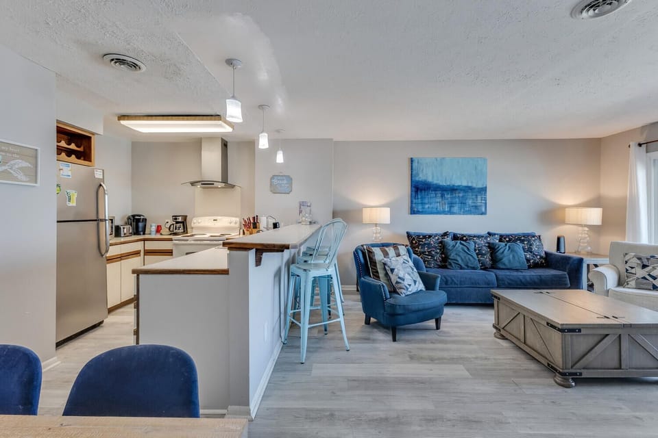 Unwind in your stylish open-concept space where coastal blues meet modern comfort—perfect for cooking, relaxing, and making vacation memories together.