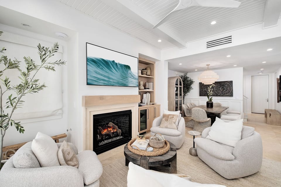 Sink into plush sofas by your crackling fireplace, where coastal art and warm textures create your perfect retreat sanctuary.