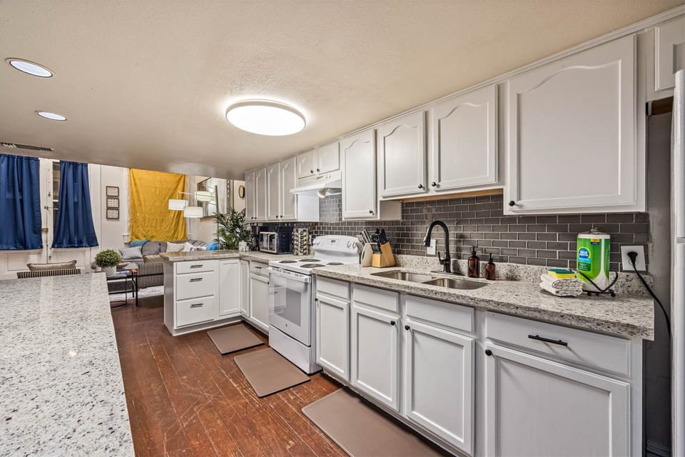 Your spacious kitchen awaits with granite countertops, white cabinetry, and everything you need to create memorable meals during your stay.