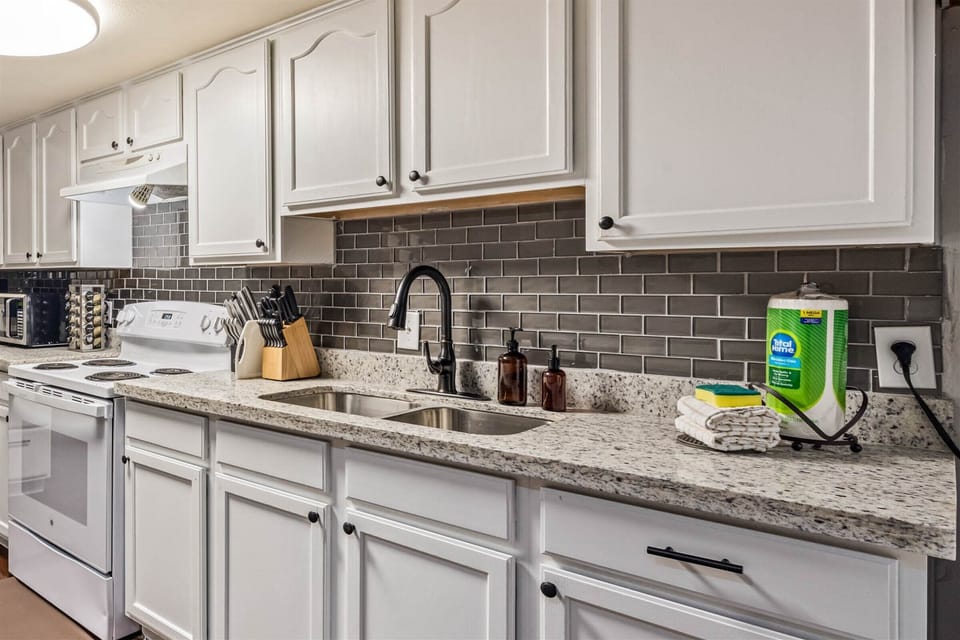 Your fully equipped kitchen awaits with granite counters, crisp white cabinets, and everything you need to create memorable meals during your stay.